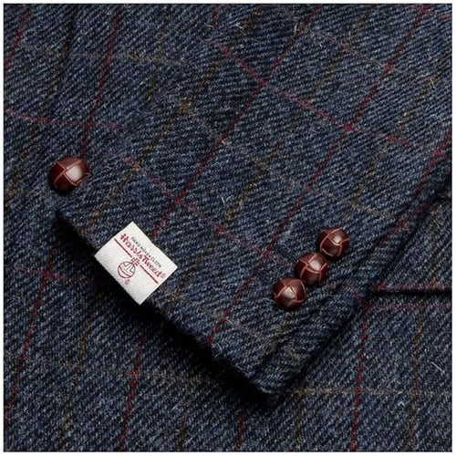 Dark blue Walker and Hawkes blazer in Harris Tweed. Subtle check with red/yellow lines. Features three brown cuff buttons and a label.