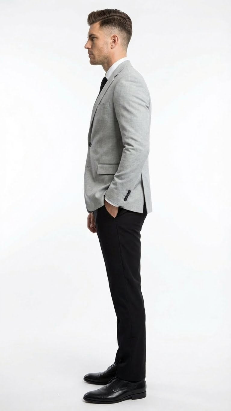 Men's light grey slim-fit blazer with structured fit, two pockets, and single-button closure. Styled with black slim-fit pants and black shoes.