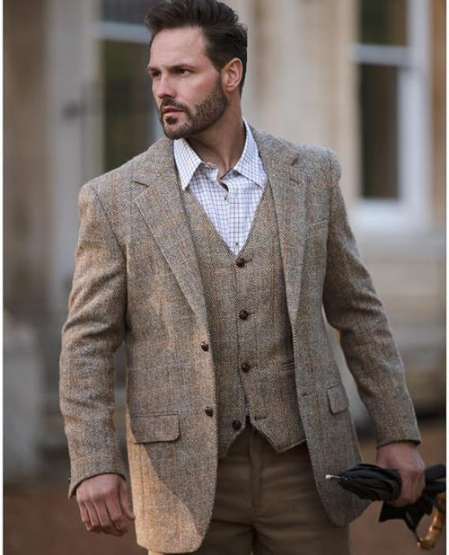 Blakemore blazer: Tailored light brown tweed. Structured fit, notched lapel, 2 pockets, 3 buttons. Coarse texture with subtle herringbone pattern. Worn over a matching vest.