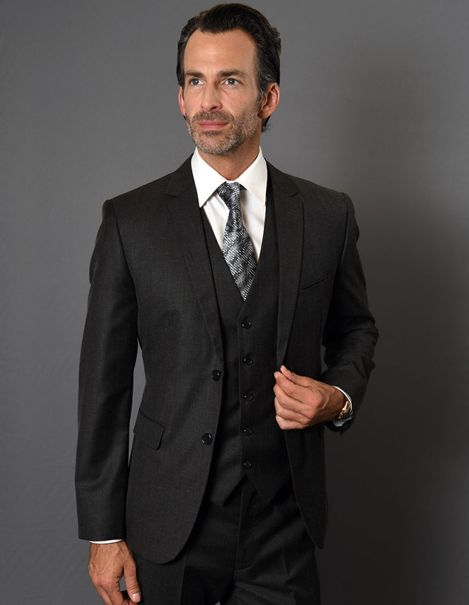 Men's slim fit, 2-button vested suit in black textured fabric. Includes jacket, matching vest, and tapered trousers. Modern fit, dark fabric.