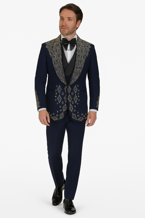 Navy men's tuxedo with tailored fit, single-button, peaked lapels, and gold geometric embroidery. Includes navy pants. Formal wear suitable fabric. Paired with white shirt and black bow tie.