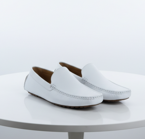 Men's white leather Mundo loafers: Classic slip-on dress shoes. Smooth white leather upper, minimalistic design, rounded toe. Stitched detail, flat sole with rubber grips for traction. Clean, streamlined look.