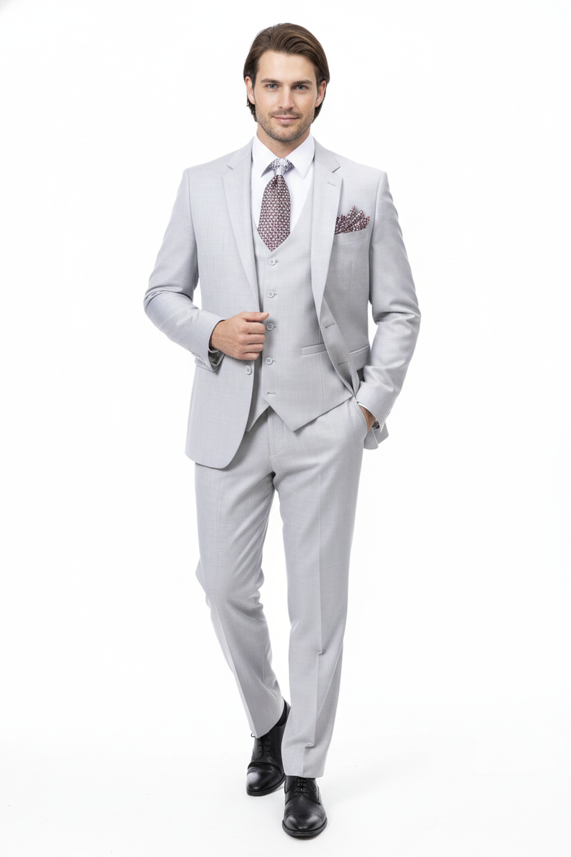 Men's light gray three-piece wedding suit. Two-button jacket, matching vest, tailored trousers. Smooth fabric with subtle texture. Perfect for a sophisticated wedding.