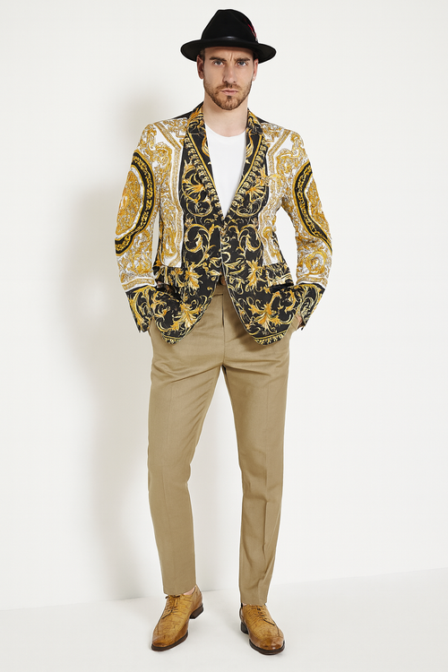 Black baroque blazer with gold detailing, paired with beige pants. Features a black hat and brown shoes. An ornate, stylish men's outfit.