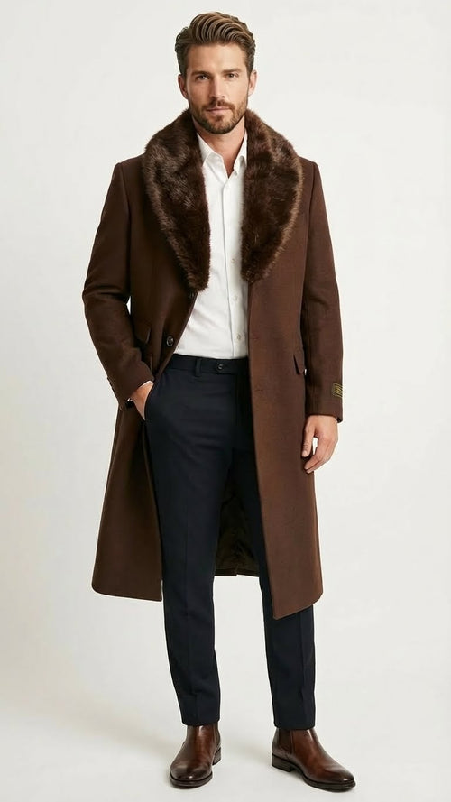 Men's brown long overcoat with dark faux fur collar, single-breasted, two buttons. Tailored silhouette, knee-length, straight cut, textured material. Paired with dark trousers.