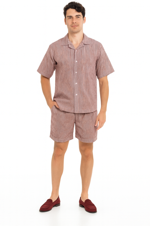 Men's burgundy seersucker short set: short-sleeve button-up shirt and shorts. Striped pattern with light/dark tones. Relaxed shorts fit just above the knee. Lightweight, textured seersucker material.
