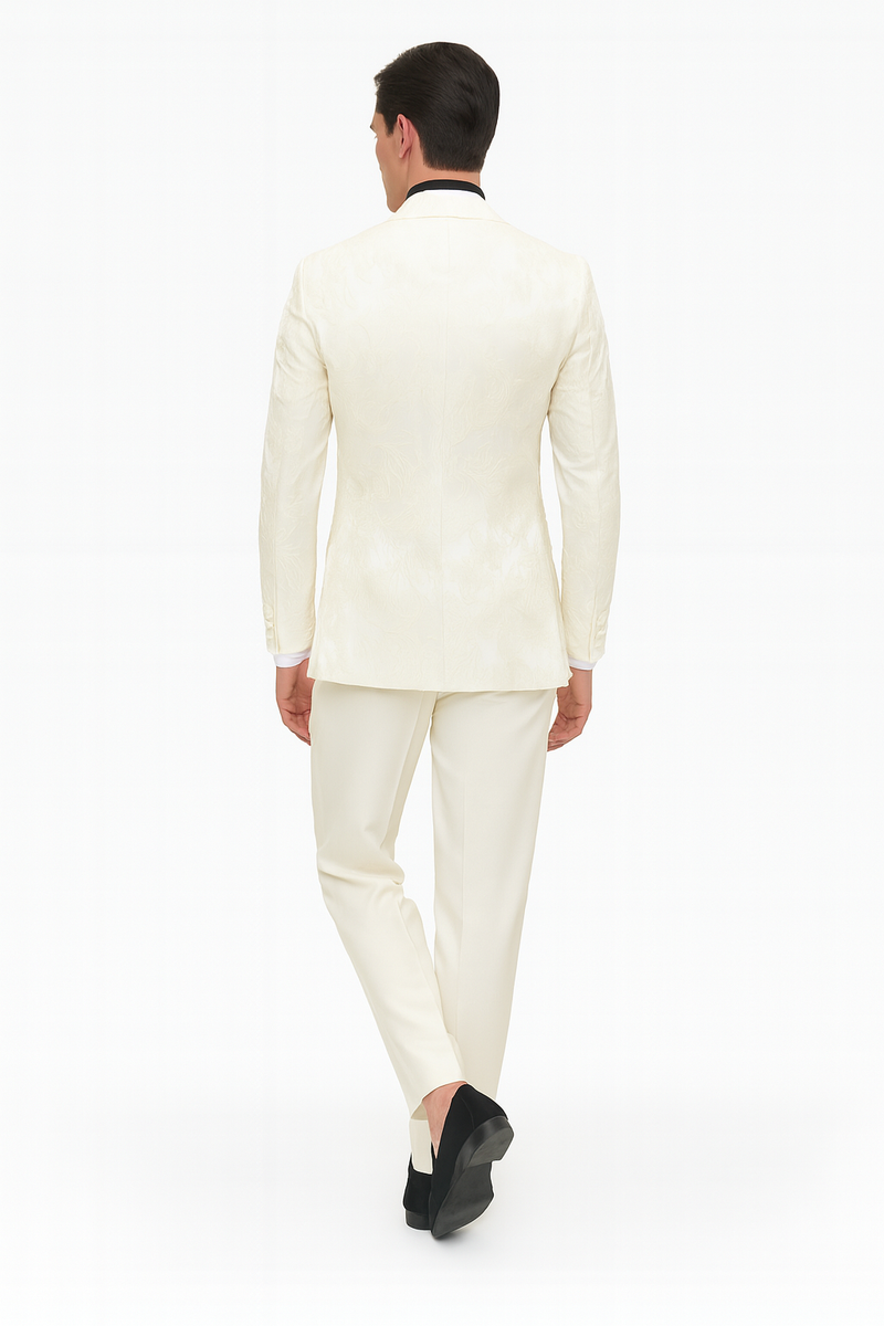 Ivory men's tuxedo jacket with floral embroidery, black collar, and matching ivory pants. Structured fit with an intricate floral pattern.