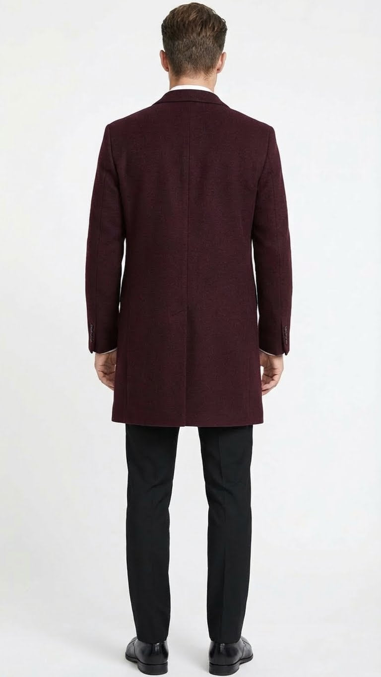 Burgundy men's mid-length overcoat in textured wool blend. Tailored fit, straight cut to above the knees, long sleeves with cuffs. Minimalist design, suitable for formal layering.