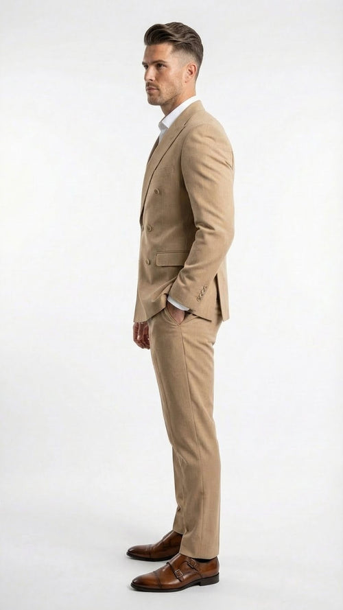 A beige double-breasted suit is depicted, featuring a tailored fit, two rows of buttons, and a notched lapel. The suit is made from a smooth fabric and presented with slim trousers.