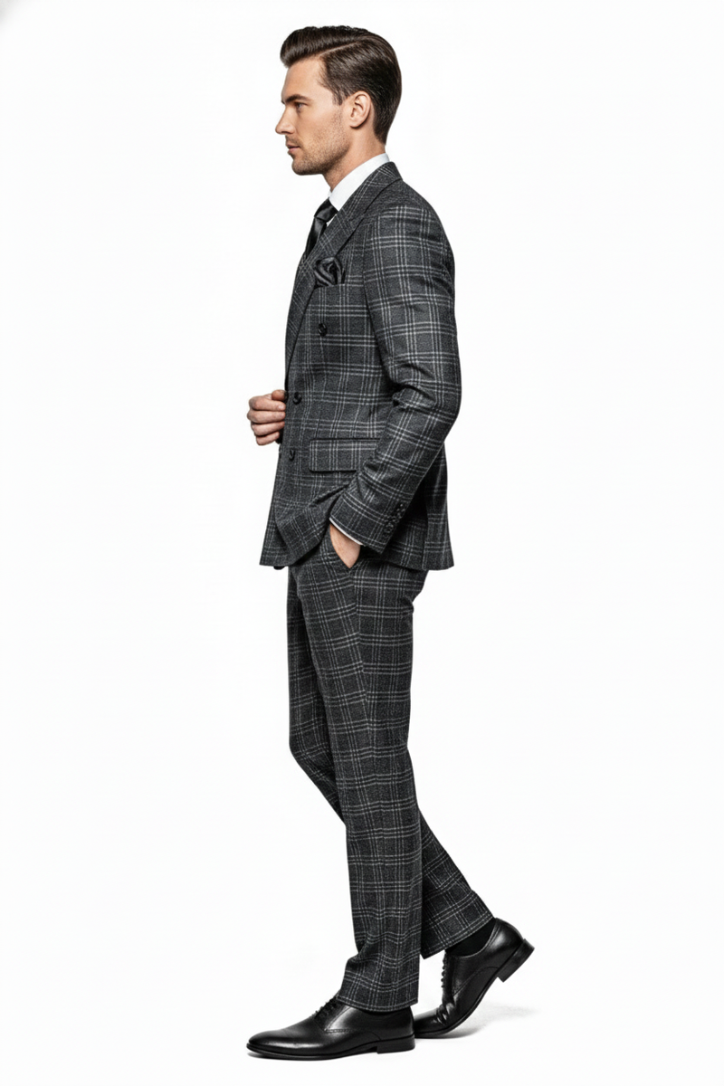 Charcoal plaid double-breasted men's suit. Structured silhouette with broad shoulders, nipped waist, straight-leg trousers. Gray fabric with black/white checks. Includes a pocket square. Model wears black dress shoes.