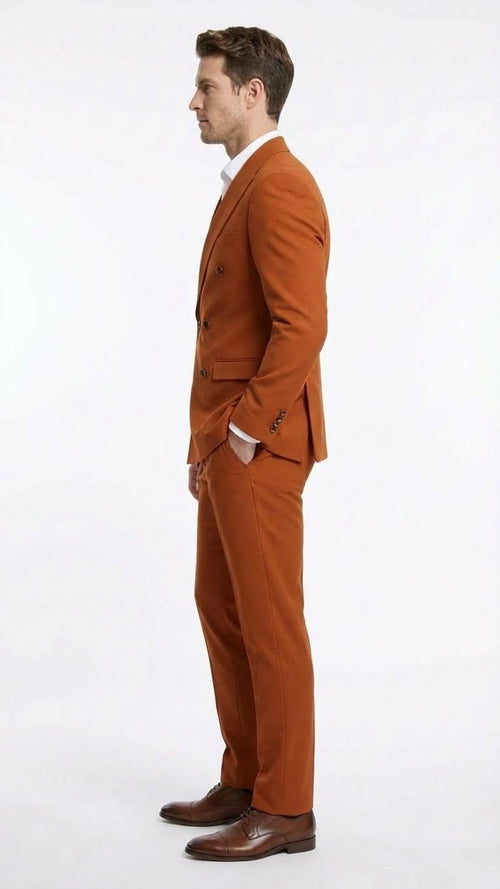 A burnt orange double-breasted suit by Alberto Nardoni features a fitted structure with straight, tailored trousers. The fabric appears to be a solid, textured weave.