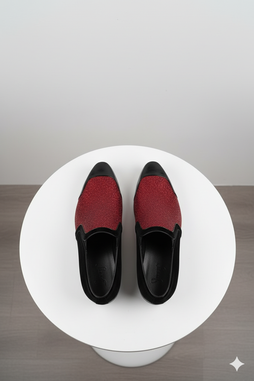 Red glitter tuxedo loafers for men: shiny red upper with textured finish, sleek black patent toe. Slip-on, rounded shape for easy wear and eye-catching style.