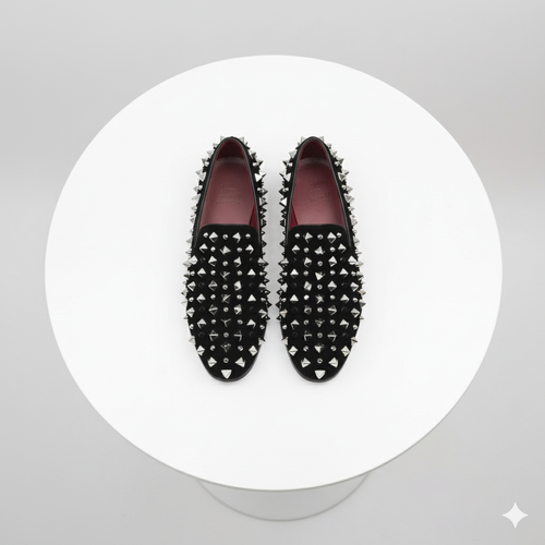 Black men's slip-on loafers with silver spikes, rounded toe, and matte finish. Burgundy lined interior.