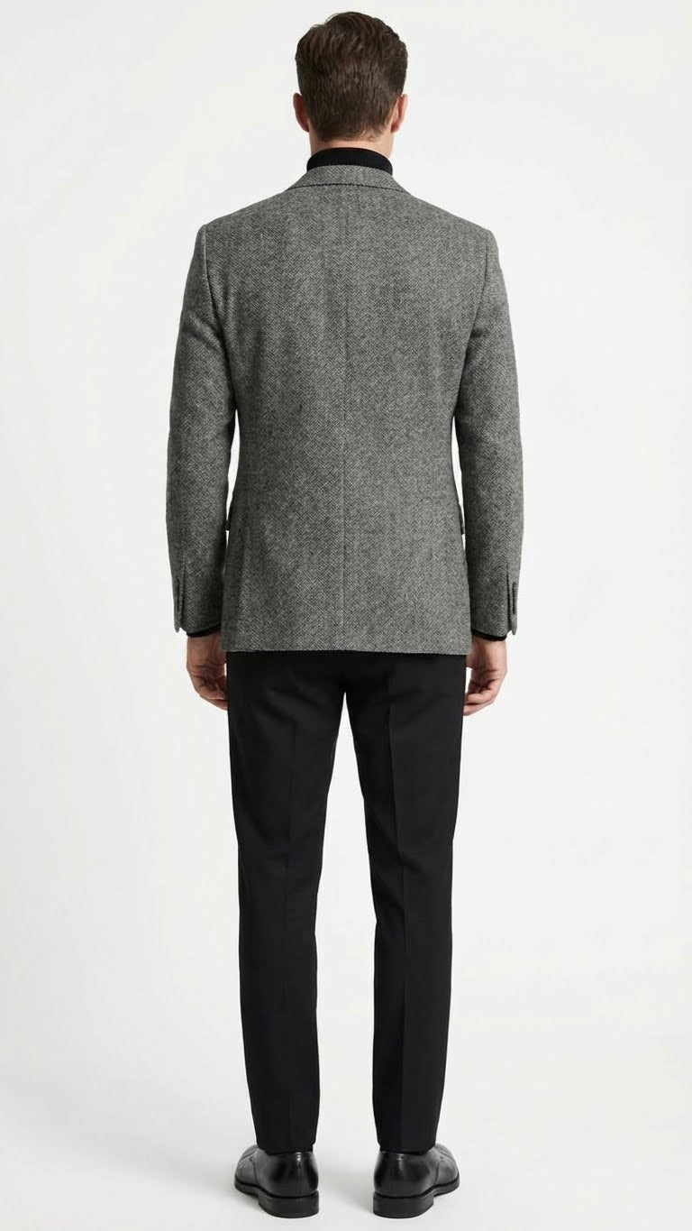 Men's grey tweed herringbone sport coat. Structured design with single vent, long sleeves, and straight waist. Classic grey herringbone pattern, black collar.