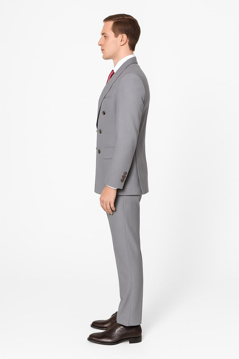 Men's light grey double-breasted suit: tailored fit, structured shape, smooth fabric. Dark buttons, slim-fit trousers included.