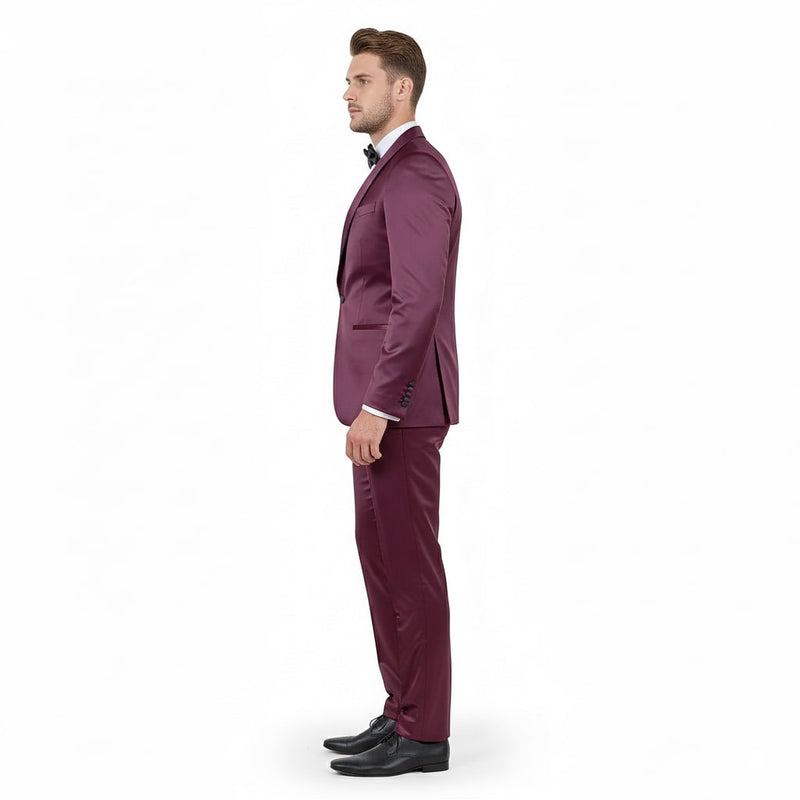 Burgundy tuxedo with satin shawl lapel. Slim fit, three-piece suit: jacket, trousers, white shirt, and bow tie. Smooth, glossy satin fabric. Formal and elegant.