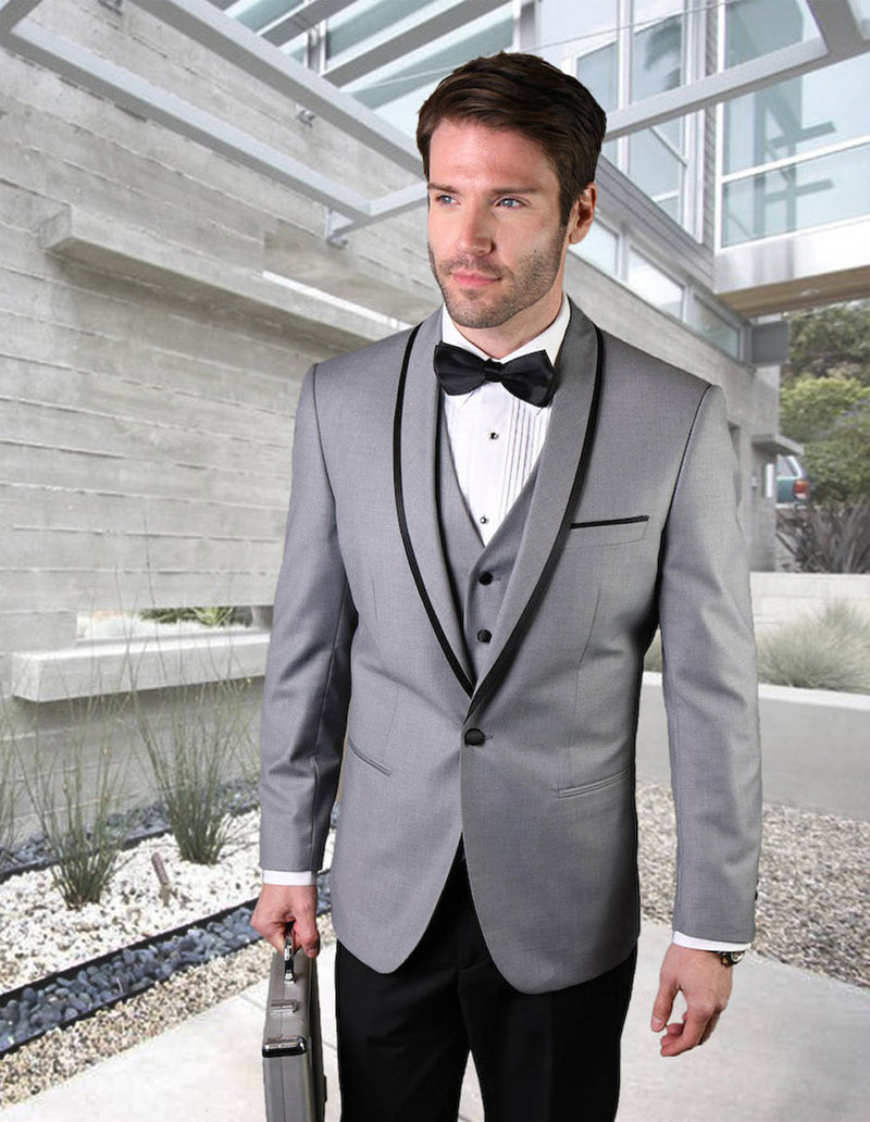 Grey wool tuxedo with shawl lapel and satin trim. Fitted shape with button closure and 3-button vest. Smooth, tailored fabric. Contrasts with dark trousers.