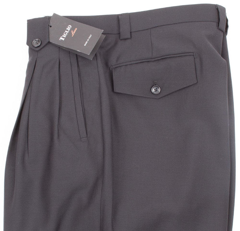 Black Tiglio Luxe wide-leg pants: high-waisted, pleated, pure wool. Features a single back pocket and relaxed silhouette, widening from hips. Sleek, solid black.
