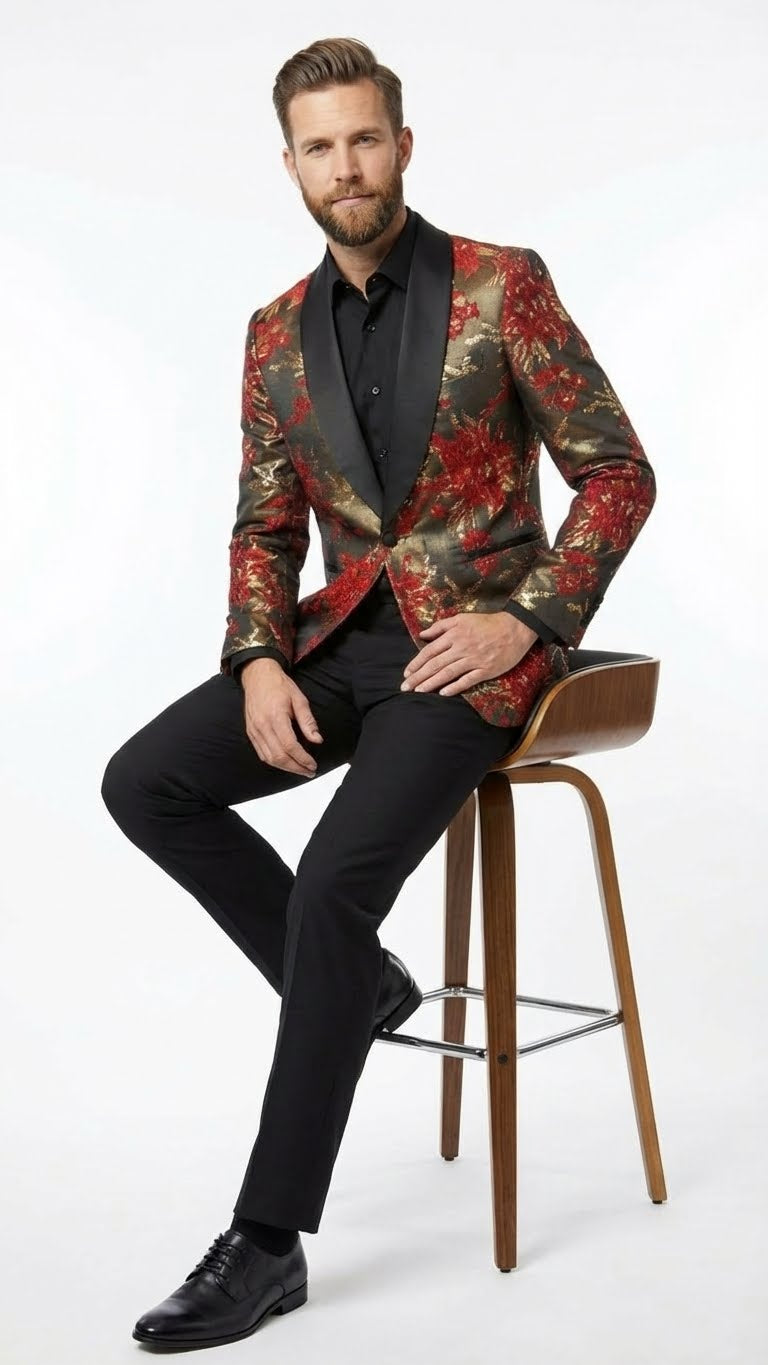 Men's red & gold paisley shawl lapel jacket. Fitted silhouette with black shawl collar. Textured fabric, vibrant floral design. Tailored shape, styled with black trousers for a cohesive, elegant look.