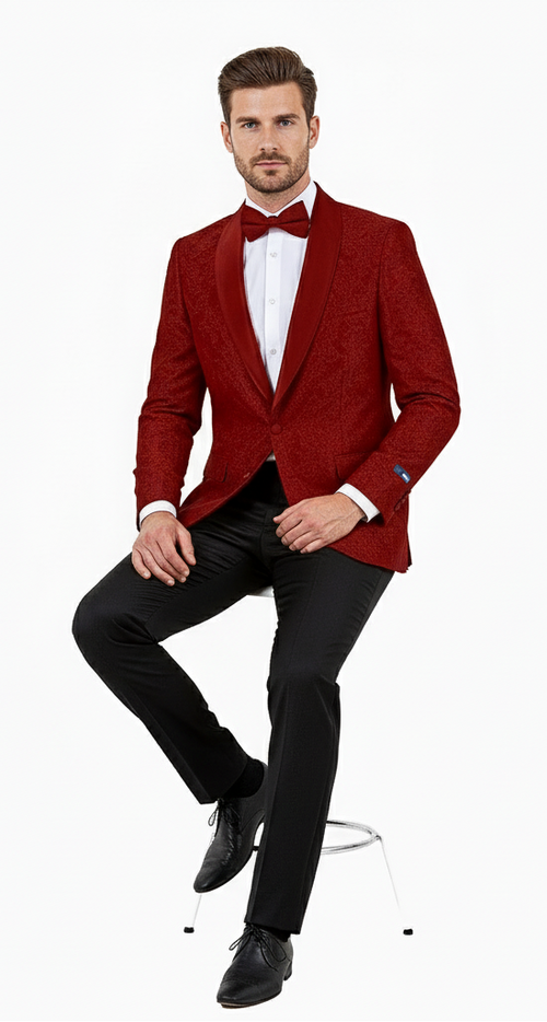 A burgundy paisley tuxedo jacket by Alberto Nardoni features a fitted structure and a textured pattern. It has a shawl collar in a darker shade and is seen with a black shirt and black trousers.