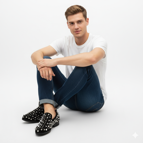 Men's black slip-on loafers with silver spikes. Rounded toe, textured black upper covered in spikes. Flat sole, likely rubber.
