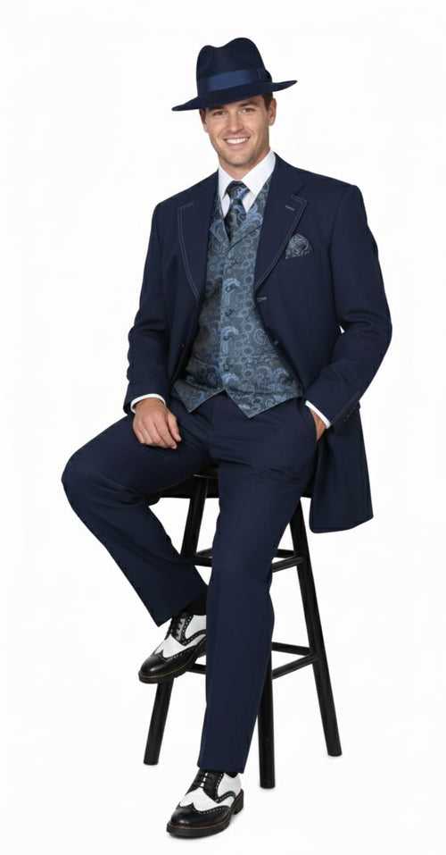 Vintage 1920s navy zoot suit for men. Includes a long jacket, pleated pants, and a patterned vest. Features white stitching, a matching fedora, and the model is wearing black and white dress shoes.