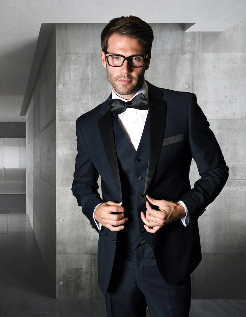 Navy blue, modern fit, 2-button wool tuxedo. Structured jacket with shawl collar, matching vest. Includes white dress shirt & black bow tie. Classic & tailored ensemble.