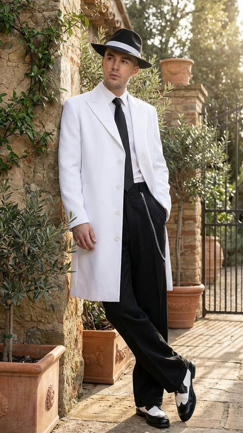 Men's white zoot suit features a long white jacket with a tailored fit, button closure, and pointed lapels, paired with black trousers and contrasting black-and-white shoes.