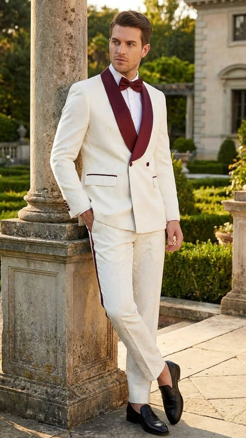 Ivory double-breasted tuxedo suit with burgundy shawl lapels & pocket detailing. Features a matching slim-fit trouser.