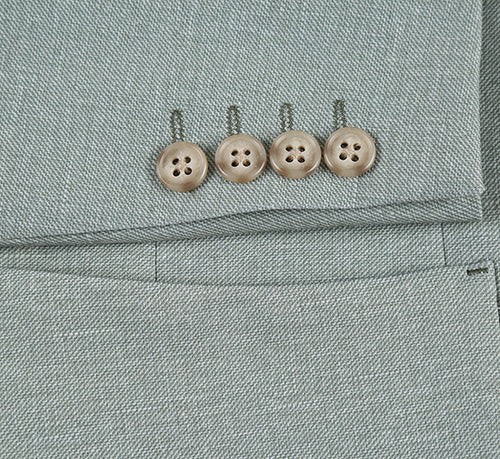 Light sage gray, slim-fit blazer with textured woven fabric. Features four light-colored sleeve buttons with semi-matte finish. Modern, tailored silhouette for a sleek fit.