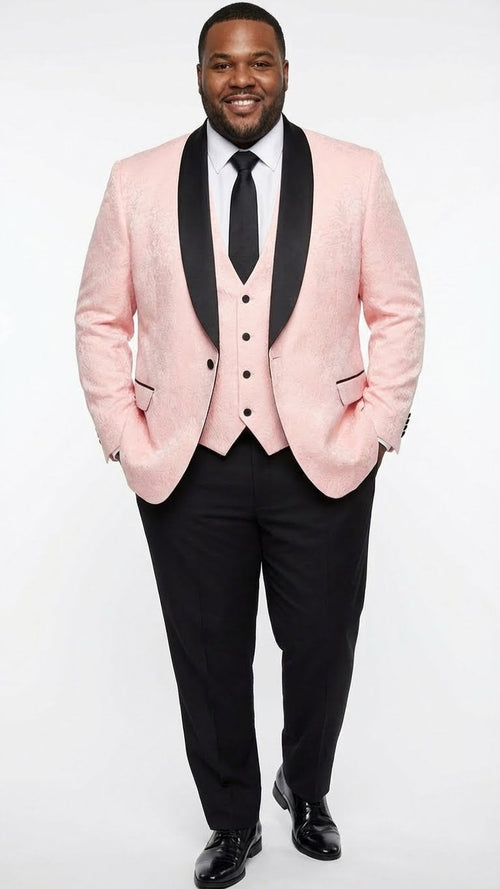 Men's blush pink tuxedo suit: textured jacket with black shawl lapel, matching vest, and black trousers. Jacket features front buttons and black pocket accents. Tailored silhouette.