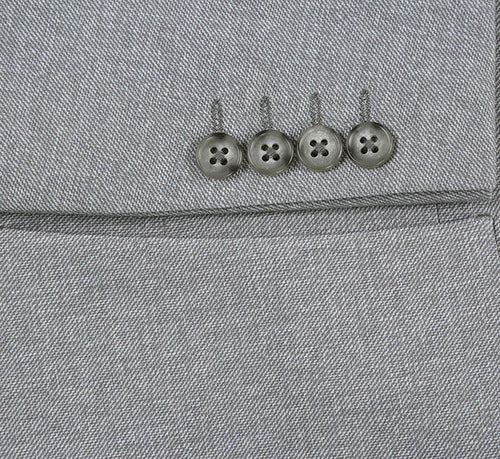 Gray, slim-fit blazer with textured herringbone fabric. Half canvas construction. Features metallic sleeve buttons and a chest pocket. A modern, tailored look.