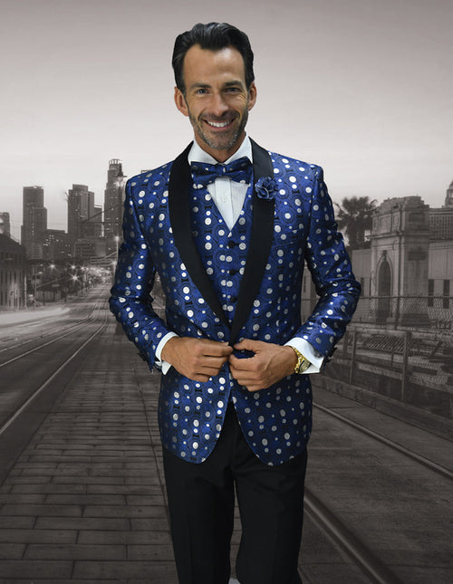Royal blue men's tuxedo with large white polka dots. Features a shiny fabric, black shawl collar, and matching vest. Stylish and eye-catching formalwear.