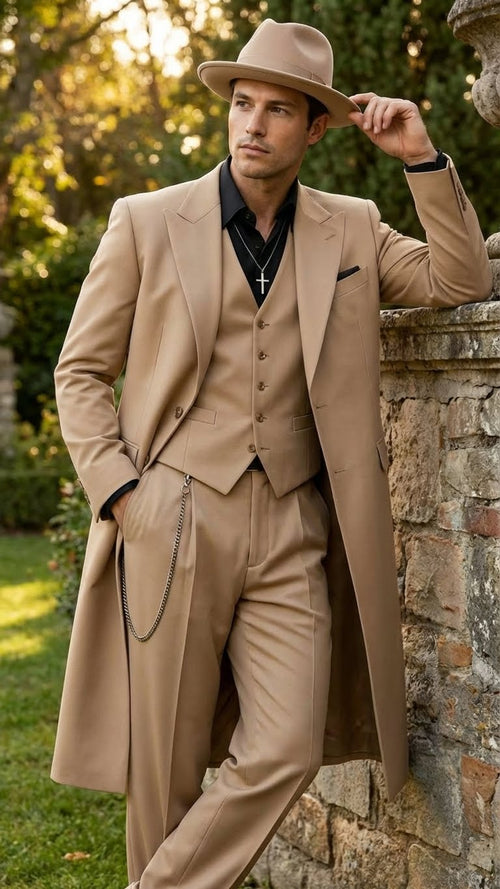 Alberto Nardoni men's 1920s beige zoot suit. Long, tailored coat with broad shoulders, fitted waist, matching vest & wide-leg trousers. Smooth fabric, single pocket square. Black shirt contrasts. Beige fedora & chain.