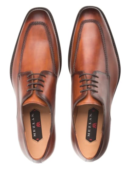 Coventry cognac calfskin oxfords: sleek elongated shape, smooth, polished finish, tonal stitching. Features a rich cognac color with darker toe, contrasting midsection and lace-up design. Tan leather inner lining.