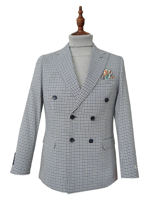Blue houndstooth double-breasted jacket with structured fit. Features broad lapels, fitted silhouette, and buttoned cuffs. Includes a patch pocket with a multicolored design. Tailored, formal aesthetic.