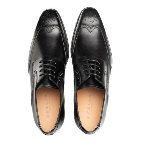 Men's black wingtip derby shoes. Smooth leather upper with decorative broguing, rounded toe, and lace-up closure. Polished black finish, cushioned insole, and wingtip details.