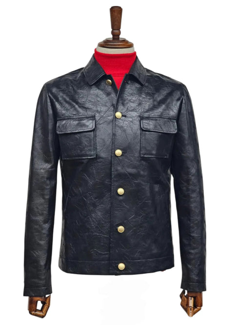 Black Alberto Nardoni men's slim fit leather suit. Five-button closure with gold-tone buttons. Features a collar, two chest pockets, tailored silhouette, long sleeves, and straight hem. Smooth leather texture.