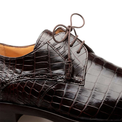 Mezlan men's brown alligator derby shoes. Genuine alligator skin upper with a unique texture. Pointed toe, lace-up closure. Sleek design with visible stitching and a structured contrasting sole.