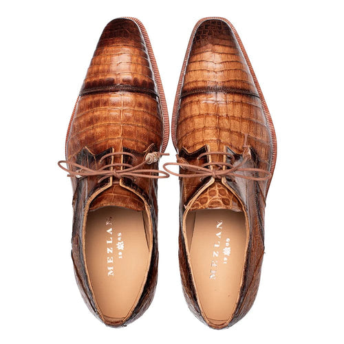Mezlan's Giovane Camel derby: genuine camel crocodile leather, cap toe, lace-up. Features a pointed toe & distinct scales. Contrasting sole edge enhances design.