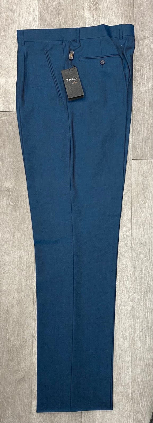 Tiglio Luxe 2521 comfort fit pants with a straight leg and 18-inch length. Solid teal blue with a smooth, slightly sheen fabric. Single front pleat, pocket, button detail, and waistband. Tag attached.