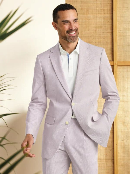 Men's lavender seersucker suit: single-button blazer with notch lapels, lightweight cotton with striped pattern. Slim-fit matching pants create a coordinated, cool look.