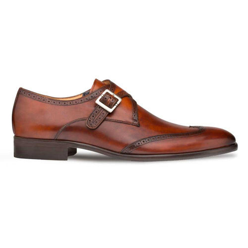 Mezlan Forest men's monk strap dress shoe in cognac calfskin. Single strap & buckle. Wingtip design with perforated detailing. Sleek, streamlined shape. Dark, flat sole for stability.