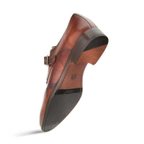 Cognac calfskin Mezlan men's monk strap with wingtip design. Single buckle closure, curved shape, slight heel, and durable rubber outsole.