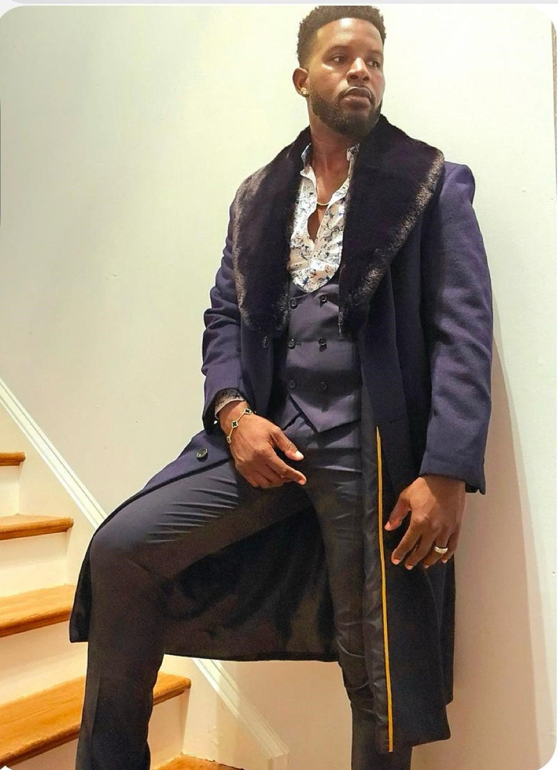 Navy blue men's overcoat with long silhouette and faux fur collar. Tailored fit with visible buttons and contrasting yellow trim. Soft material and structured design.