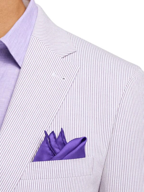 Men's cotton blazer in lavender and white seersucker. Features textured fabric, purple pocket square, notched lapels with stitching detail.