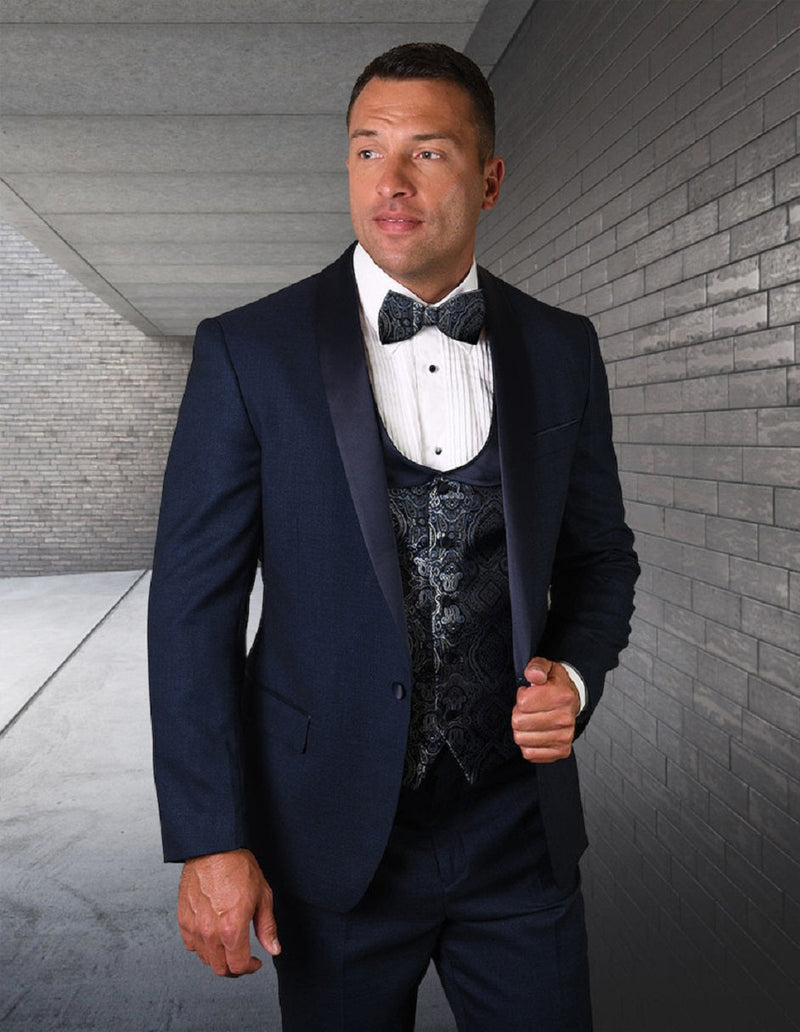 Indigo blue one-button shawl tuxedo with fitted silhouette. Features paisley vest & satin lapel. Paired with a white pleated shirt and bow tie.