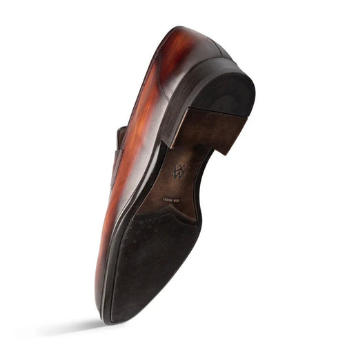 Mezlan's men's Avenue penny loafers in cognac rust. Sleek, low-profile, rounded toe, penny strap. Smooth, rich leather upper with subtle sheen. Contrasting heel, textured sole for grip.
