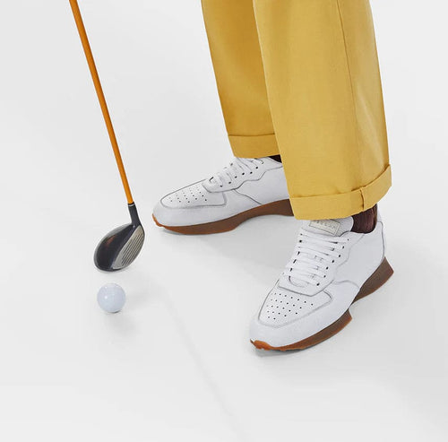 Mezlan Gerardo men's sneakers: white deerskin upper with perforations. Brown rubber sole, low profile, rounded toe, and lace-up closure. Offers breathability and style.