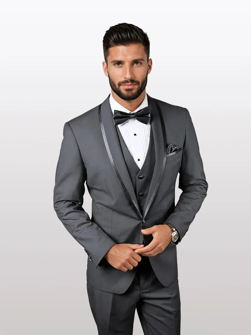 Mens charcoal vested tuxedo features a shawl lapel and bowtie, constructed from sleek fabric. The suit displays structured, tailored form with a three-button front and a fitted silhouette.